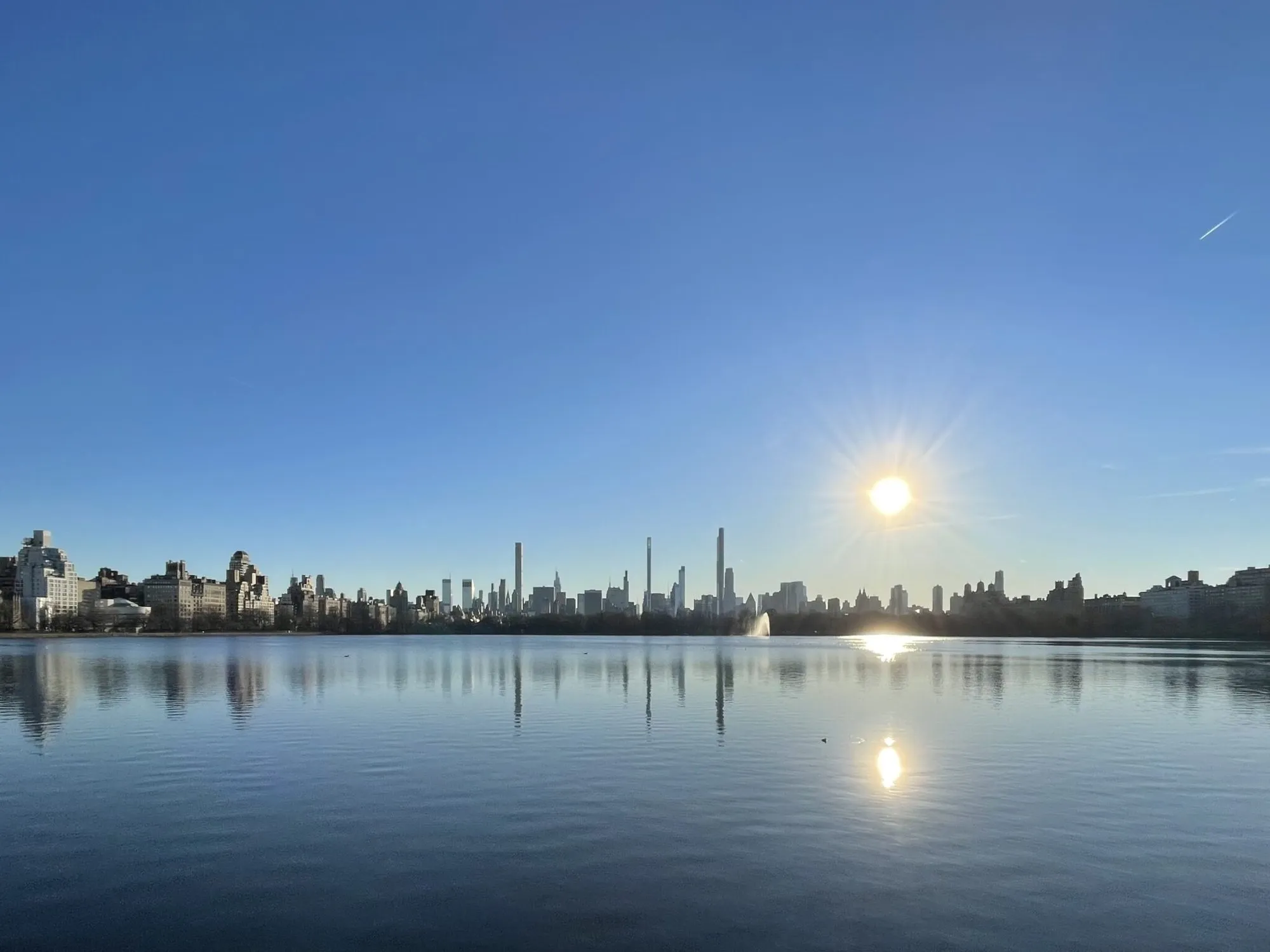 The Central Park Reservoir at dawn, with the Manhattan skyline in the distance.
